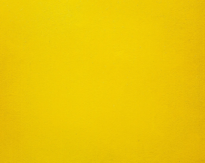 A solid bright yellow wall with a smooth matte texture